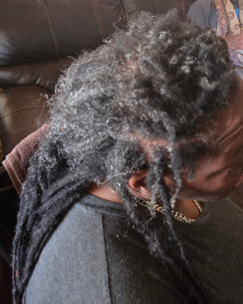 A before image of a woman who needed a reinstall loc service at The Queens Den of Isan's Naturals,