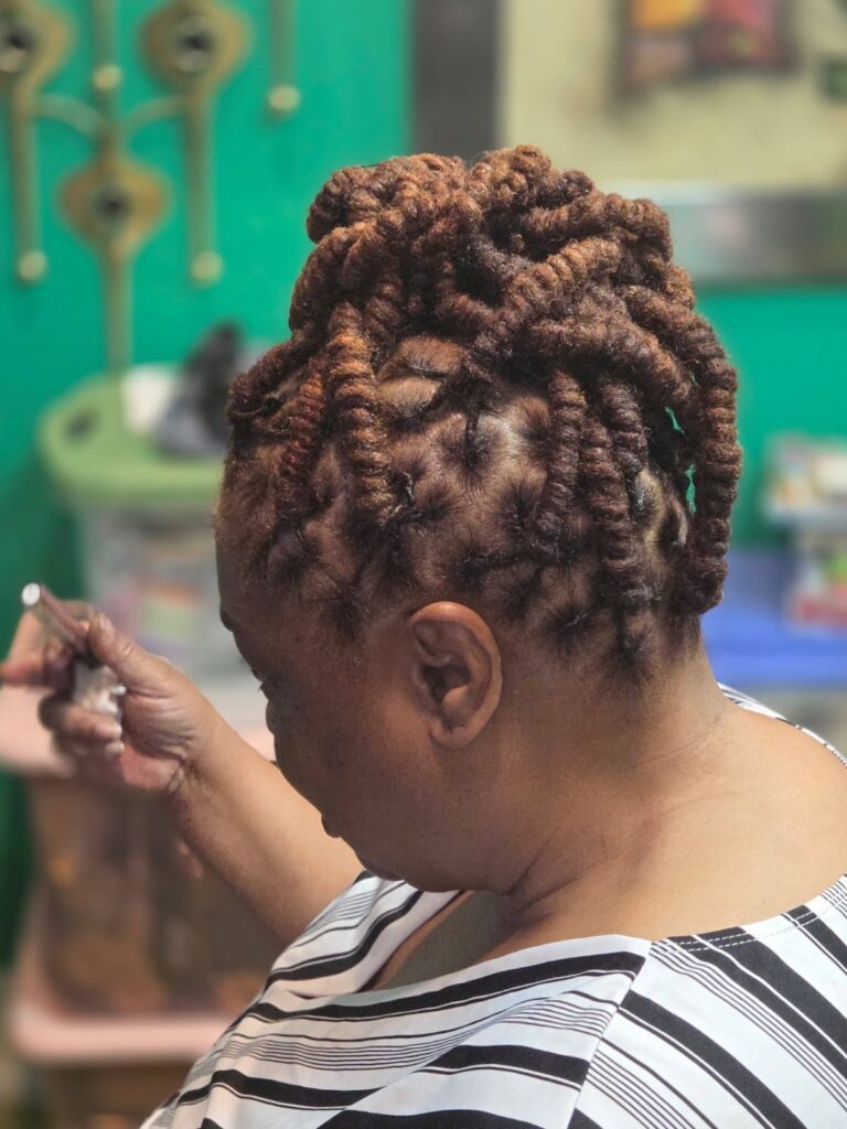 A woman with styled locs from the Queens Den 